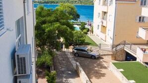 A coastal building with a swimming pool, a car parked in front, and a view of the sea. - Apartments Gabi - Two Bedroom/Balcony/SeaView (A3) (Srima)