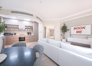 A modern apartment with a kitchen, dining area, and living room. There is a 'BOOK ME' sign on the wall. - Stayshort - 2 Bedroom in Dubai Marina With Huge Balcony (Dubai)