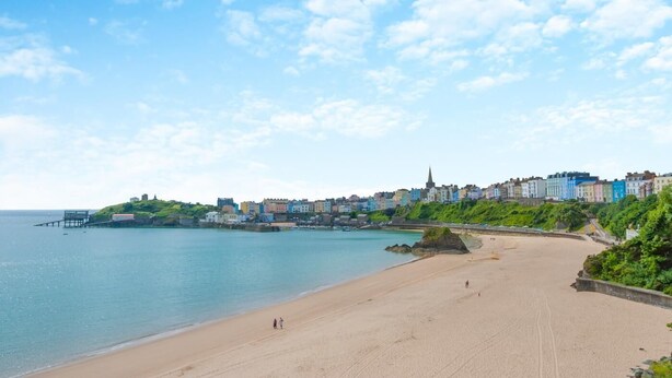 A coastal town with a sandy beach, a pier, and colorful buildings along the shore. - 3 Bed in Tenby (oc-t30644) (Tenby)