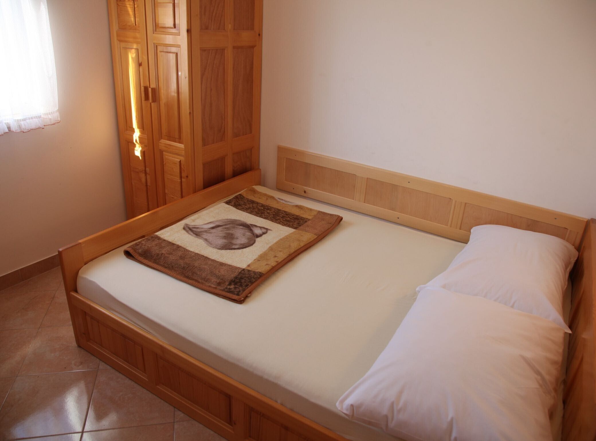 Een enkel bed met een houten hoofdbord en een sprei met een ontwerp van een beer.