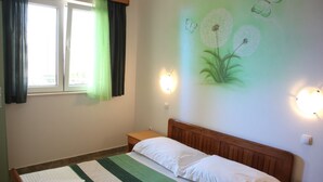 A bedroom with a bed, a nightstand, a window with curtains, and wall-mounted lights. - Apartments Gabi - One Bedroom/balcony/sea view(B4) (Srima)