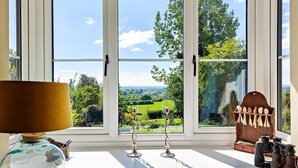 Una habitación con un ventanal que ofrece vistas a un paisaje verde.