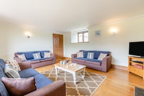 A living room with two sofas, a coffee table, and a TV stand. - 4 Bed in St. Endellion (oc-t30725) (Trelights)