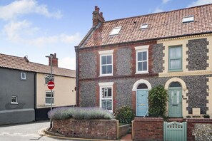 A two-story building with a tiled roof, a 'no entry' sign, and a small garden area. - 4 Bed in Sheringham (oc-s30767) (Sheringham)