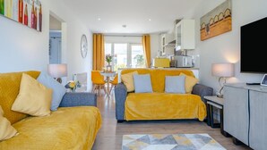 Ein modernes Wohnzimmer mit zwei Sofas, einem Essbereich und einer Küche.