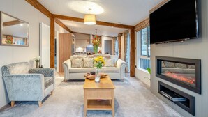 A modern living room with a sofa, armchairs, a coffee table, and a fireplace. - 2 Bed in St. Fillans (oc-l30650) (Saint Fillans)
