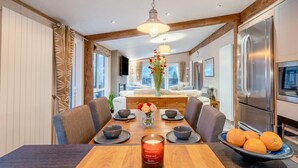 A modern dining area with a wooden table, chairs, and a candle centerpiece. - 2 Bed in St. Fillans (oc-l30650) (Saint Fillans)