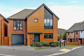 A modern two-story residential building with a brick facade, large windows, and a garage. - 4 Bed in Seaton (oc-a89856) (Seaton)