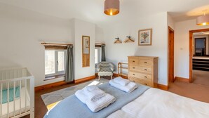 A bedroom with a bed, a dresser, a chair, a crib, and a window with curtains. - 4 Bed in East Allington (oc-k30711) (East Allington)