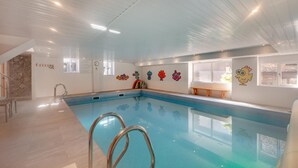 An indoor swimming pool with a clear pool area, a wooden bench, and colorful wall decorations. - 3 Bed in East Allington (oc-m30710) (East Allington)