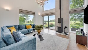 Een moderne woonkamer met een blauwe bank, een salontafel en een open haard.