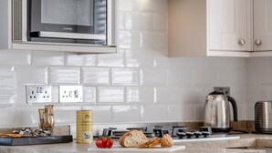 Une cuisine équipée d’un four à micro-ondes, d’une cuisinière et de divers aliments disposés sur le plan de travail.