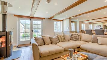A modern living room with a sectional sofa, a fireplace, and a dining area with chairs.