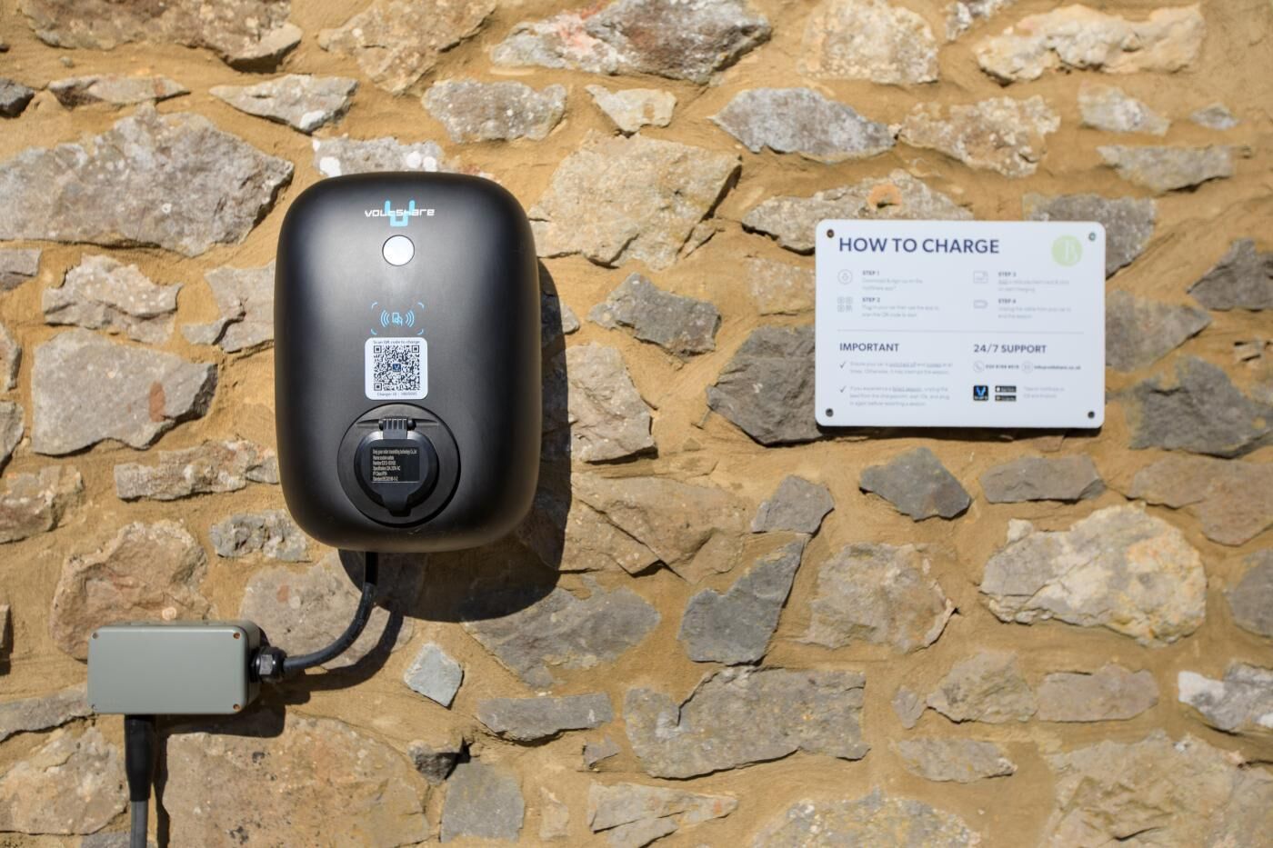 Een draagbare oplaadstation met een QR-code en een bord met laadinformatie.