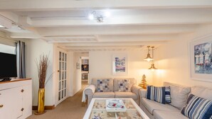 A living room with a sofa, coffee table, TV, and a decorative vase. - 2 Bed in Brixham (oc-w30730) (Brixham)