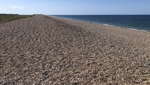 Una playa de guijarros con cielo despejado.