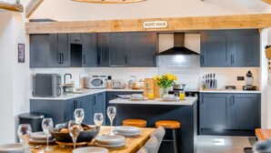 Uma cozinha moderna com armários escuros, uma ilha central e um letreiro com a inscrição 'HAPPY HOUR'.