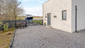 A building with a gravel driveway and a boat docked outside. - 1 Bed in Coldingham (oc-c30814) (Coldingham)