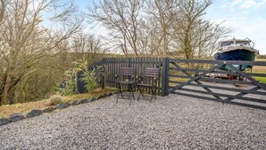 A gravel path leading to a wooden gate with a bench and a table. - 1 Bed in Coldingham (oc-c30814) (Coldingham)