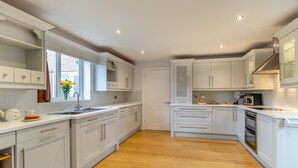 Eine moderne Küche mit weißen Schränken, Holzboden und einem eingebauten Backofen.