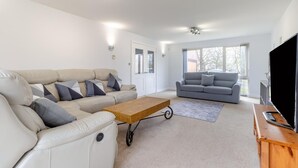 Ein modernes Wohnzimmer mit zwei Sofas, einem Couchtisch und einem Fernseher.