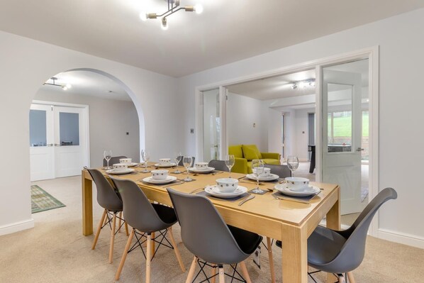 Comedor con mesa de madera dispuesta para seis personas, rodeada por seis sillas.