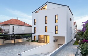 A modern two-story building with a flat roof, large windows, and a paved courtyard. - Beautiful apartment in Zadar (Zadar)