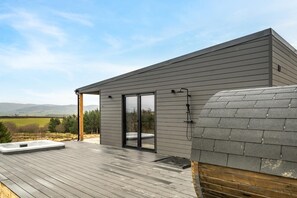 Une maison moderne dotée d’une terrasse, d’un sauna et offrant une vue sur la campagne.