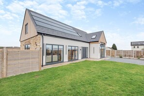 A modern house with a large glass door entrance, a stone facade, and a sloped roof. - 4 Bed in Pleasley Vale (oc-c30857) (Mansfield Woodhouse)