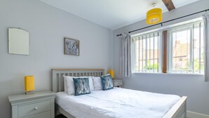 A bedroom with a bed, bedside tables, a nightstand, a window with curtains, and a ceiling light. - 2 Bed in Horsham St. Faith (oc-b30838) (Horsham Saint Faith)