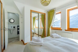 A bedroom with a bed, a mirror, a window, and a view of mountains. - 3 Bed in Letter Finlay (oc-l30952) (Altura)