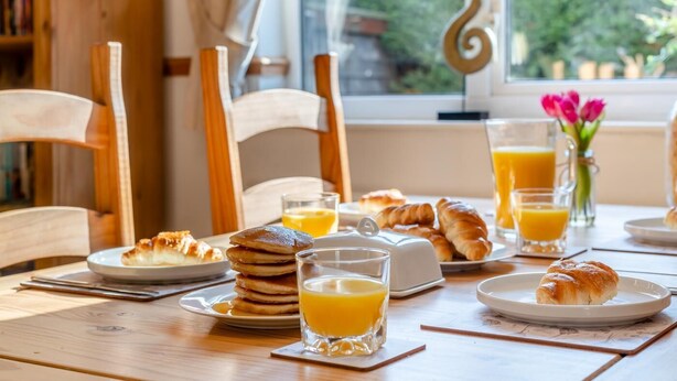 A breakfast table with pancakes, croissants, and orange juice glasses. - 2 Bed in Welney (oc-o30872) (Welney)