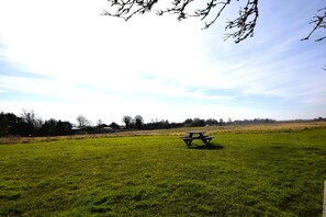 A picnic table in a grassy field with a clear sky. - 2 Bed in Welney (oc-o30872) (Welney)