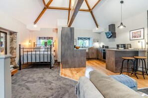 Moderni loft-tyylinen asunto, jossa on makuuhuone, pieni keittiö ja oleskelutila.