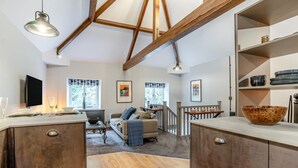 A spacious kitchen with wooden beams, a dining area with a sofa, and a staircase leading to another level. - 1 Bed in Nant-y-derry (oc-g30807) (Nant-y-derry)