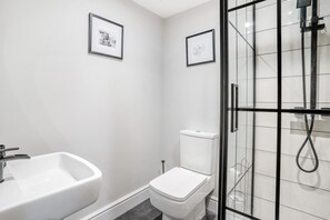 A bathroom with a white sink, toilet, and glass-enclosed shower. - 2 Bed in Nant-y-derry (oc-c30806) (Nant-y-derry)