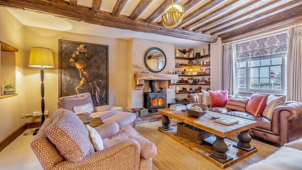 Una sala de estar acogedora con chimenea, sofás de cuero y una mesa de centro de madera.