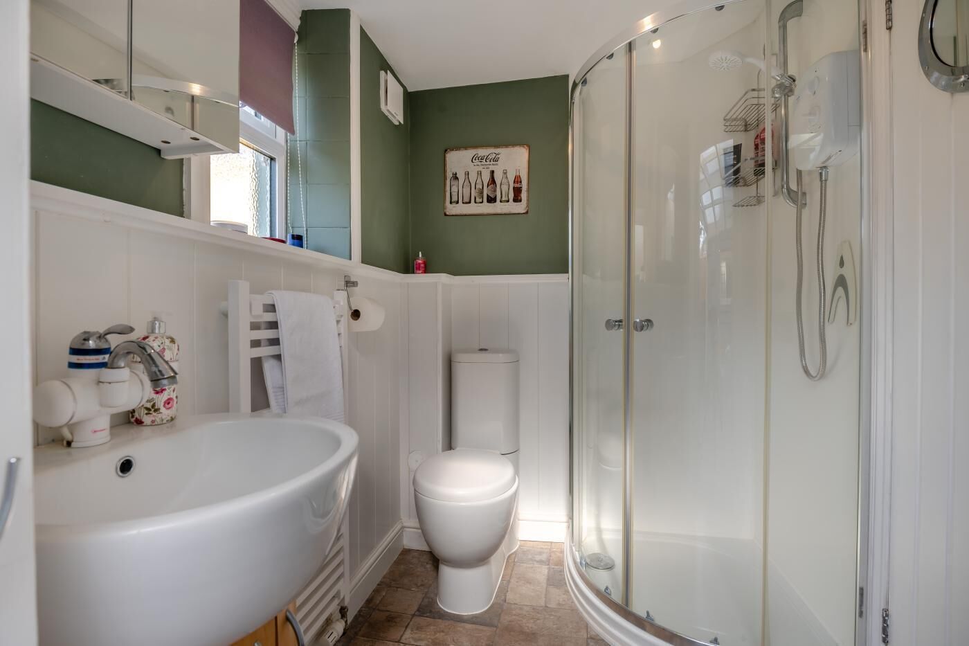 A bathroom with a bathtub, toilet, and glass-enclosed shower.