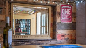 A rustic interior with a wooden wall, a mirror, and a sign that reads "I WILL ONLY HAVE ONE GLASS OF WINE TONIGHT." - 2 Bed in Wimborne (oc-s30924) (Wimborne)
