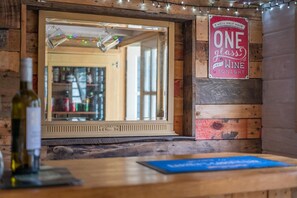 Un interior rústico con una pared de madera, un espejo y un letrero que dice 'TONIGHT I WILL ONLY HAVE ONE GLASS OF WINE'.