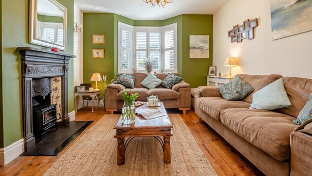 A cozy living room with a fireplace, two sofas, a coffee table, and a chandelier. - 2 Bed in Wimborne (oc-s30924) (Wimborne)