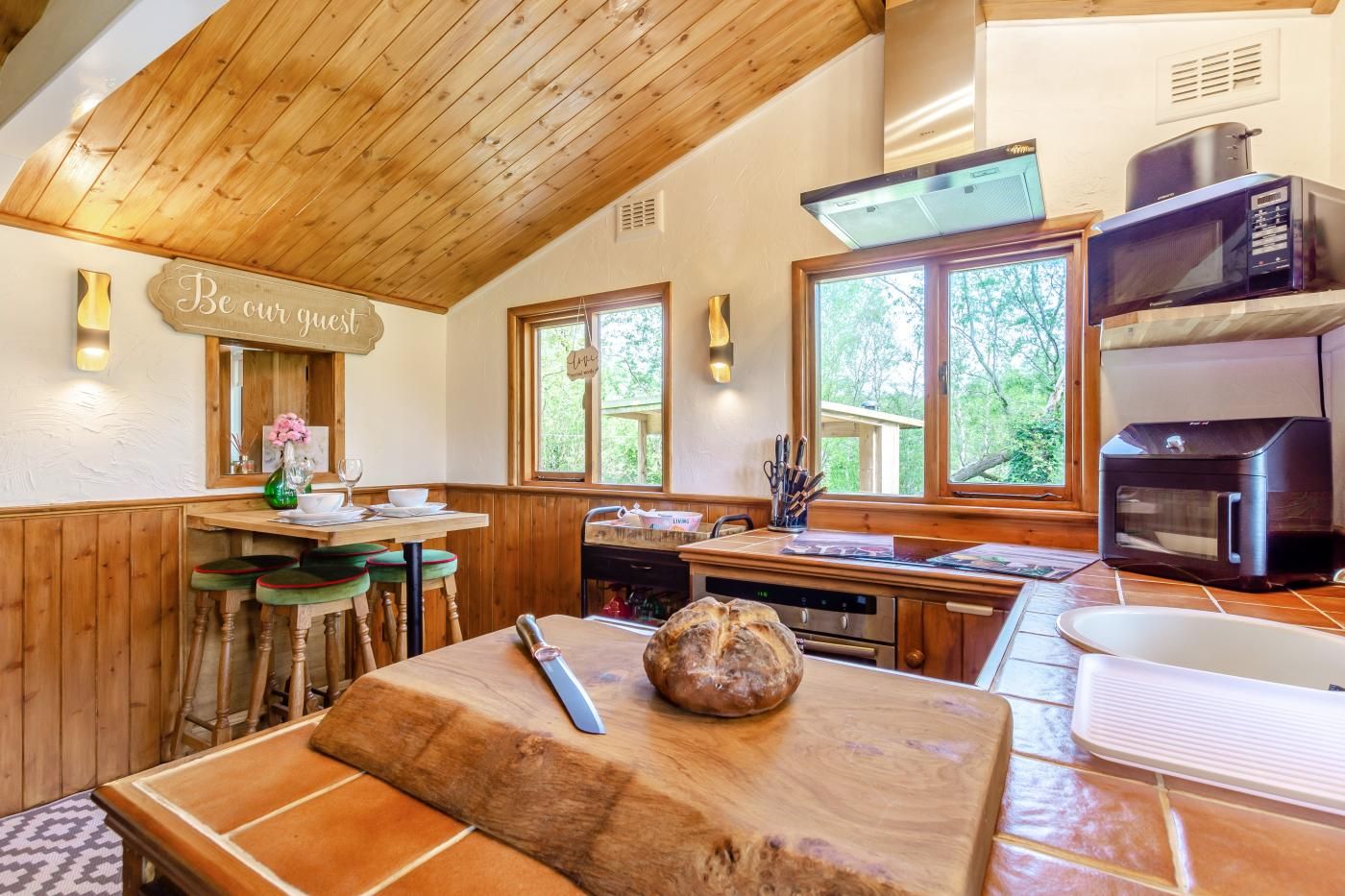 A rustic kitchen with wooden beams, a wooden countertop, and a bread loaf.