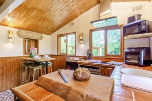 A rustic kitchen with wooden beams, a wooden countertop, and a bread loaf.