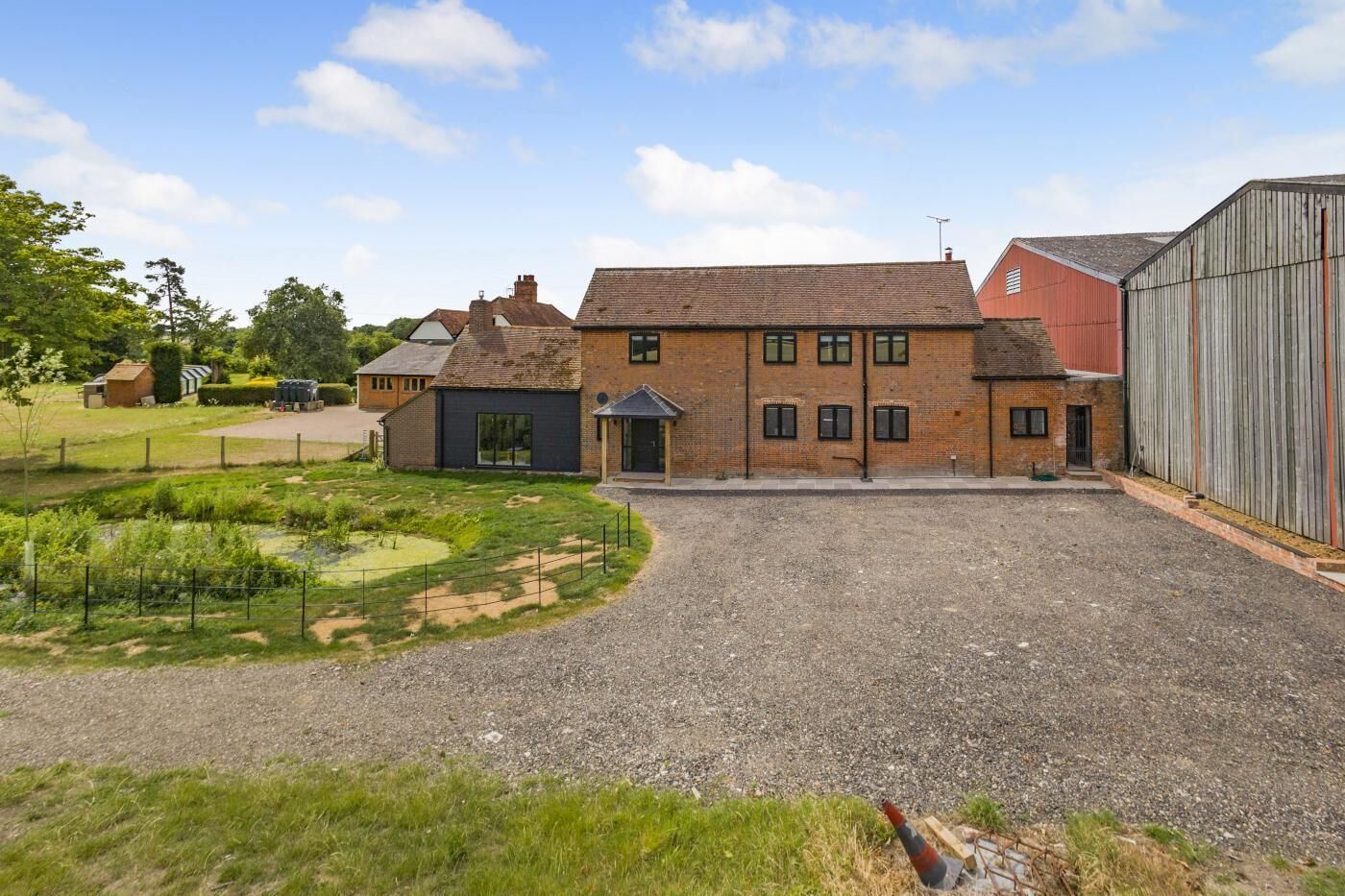 A large building with multiple windows and a gravel driveway.