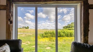 Una habitación con un ventanal que ofrece vistas a un campo cubierto de hierba y árboles.