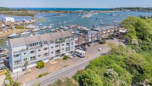 A marina with boats, a modern building with multiple floors, and a parking area. - 3 Bed in St. Helens (oc-y30961) (Saint Helens)