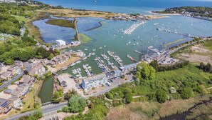 An aerial view of a marina with boats docked, surrounded by residential buildings and greenery. - 3 Bed in St. Helens (oc-y30961) (Saint Helens)