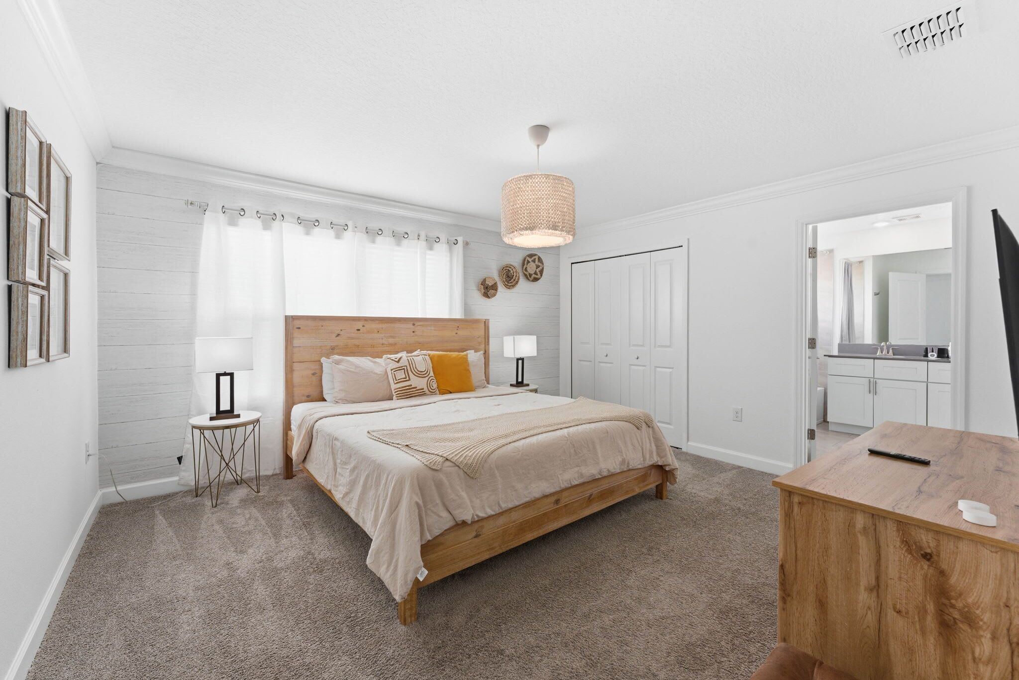 A bedroom with a wooden bed, a bedside table, a lamp, a mirror, and a wardrobe.