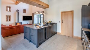 Una cucina moderna con isola centrale, elettrodomestici integrati e un'ampia finestra.