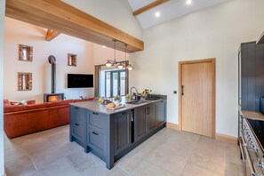 Une cuisine moderne dotée d’un îlot central, d’appareils électroménagers intégrés et d’une grande fenêtre.